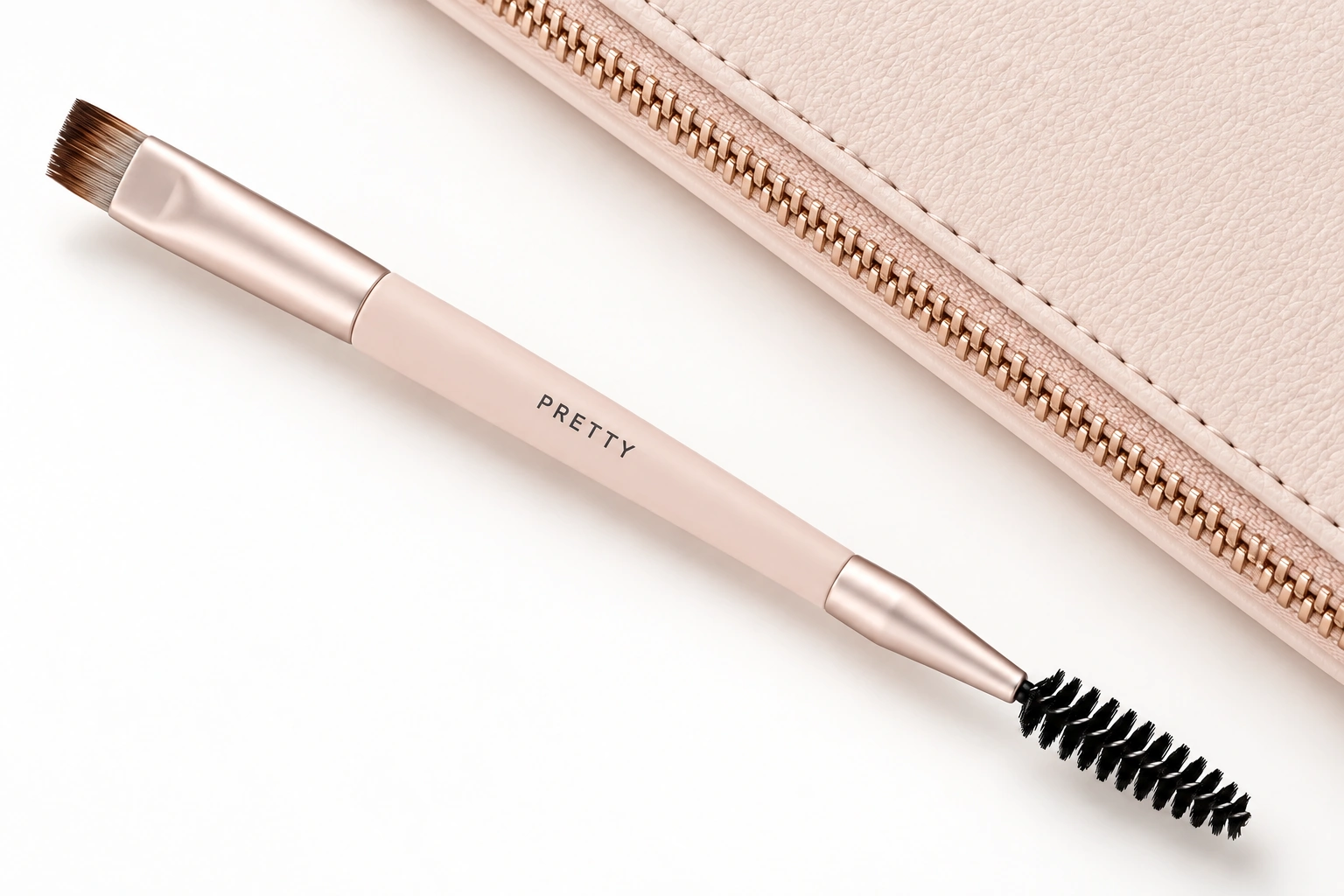 AI packaging detail study of a pale pink PRETTY angled brow brush and spoolie beside an ivory case and champagne-tone zip