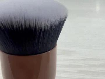 Brown compact brush with a flat bristle surface