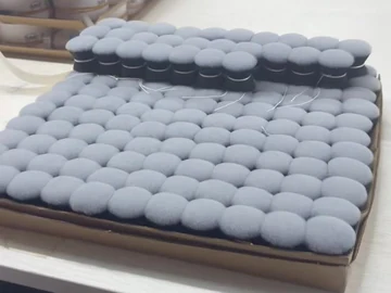 Grey brush heads arranged beside cartons