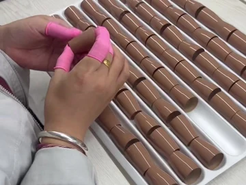 Hand work on a compact brush beside body trays