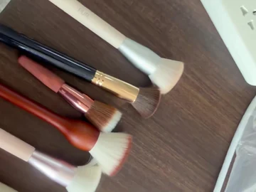 Long brown-handle brushes on a wooden table