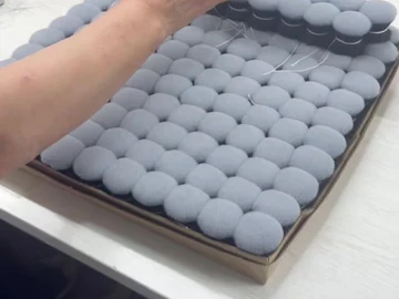 Hand work beside trays of compact brush heads