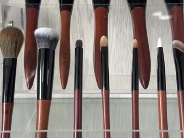 Brown-handle face and eye brushes on a display stand