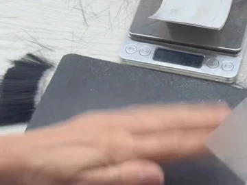 Brush-head handling beside a dark work mat