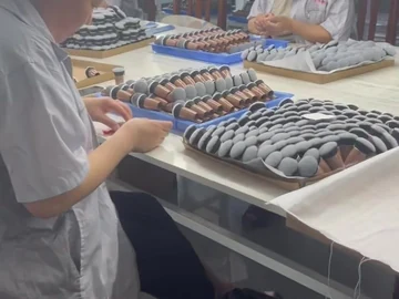 Operators working beside trays of compact brushes