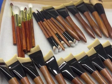 Long brown-handle brushes arranged in a tray