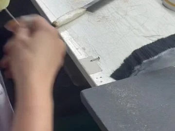 Brush-head hand work beside small binding loops