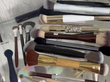 Long-handle brush samples on a glass shelf