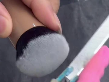 Close view of scissors at the edge of a brush head