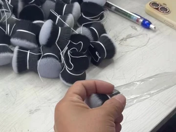 Hand handling a brush beside loose head bundles