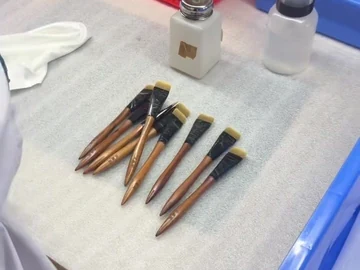 Brown-handle brushes beside workshop supply bins