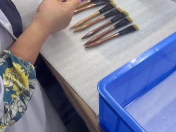 Gloved hand work on the long-handle brush group
