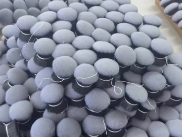 Tray densely arranged with round grey brush heads