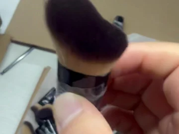 Angled compact brush held above a sample batch